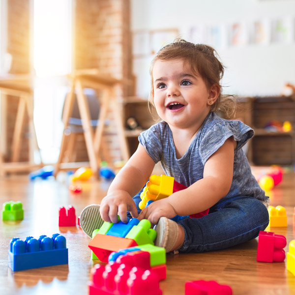 toddler playing with blocks on the floor